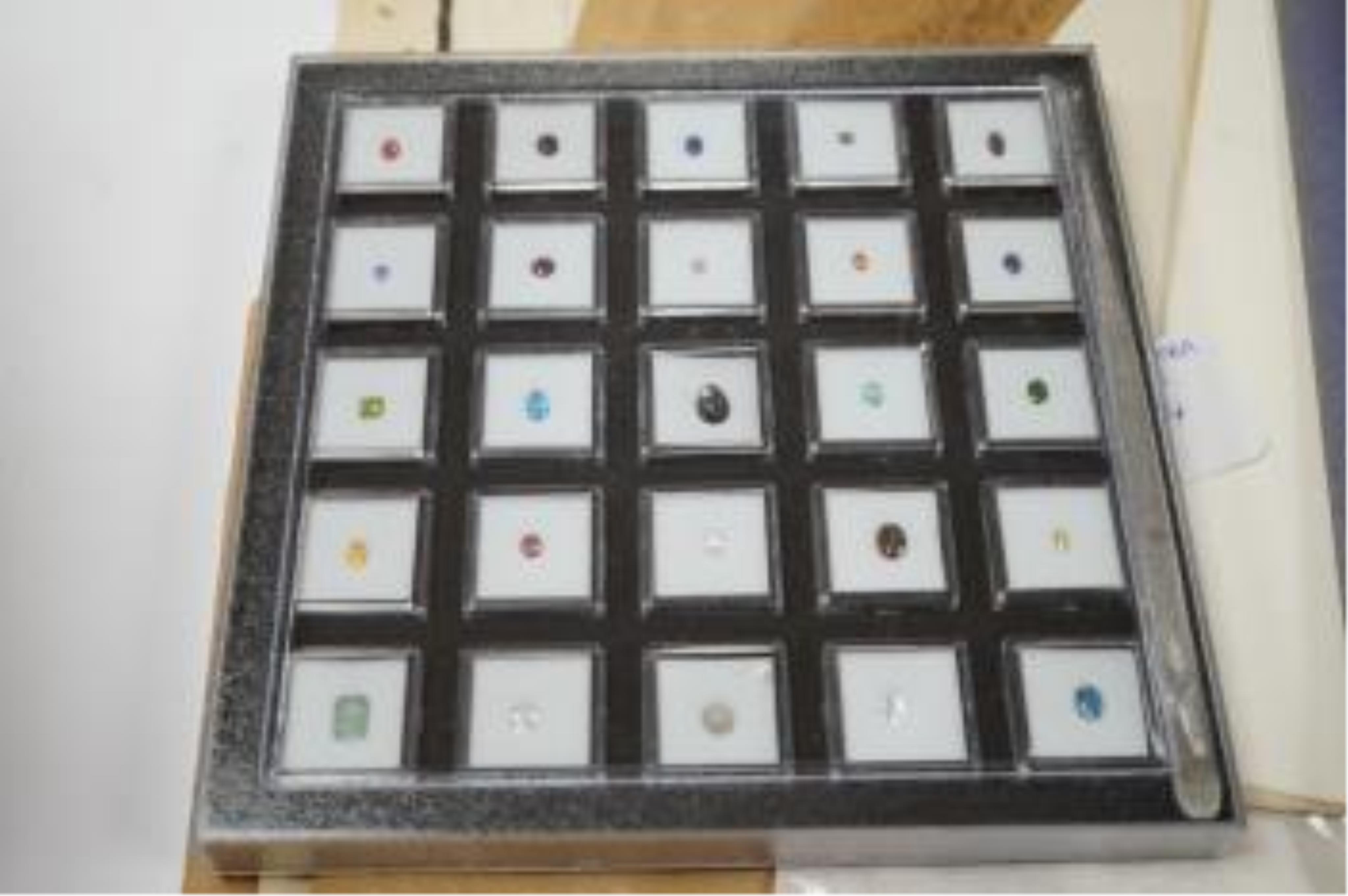 Three boxes containing unmounted cut gemstones including topaz, citrine, peridot, zircon, moonstone, etc. Fair condition.